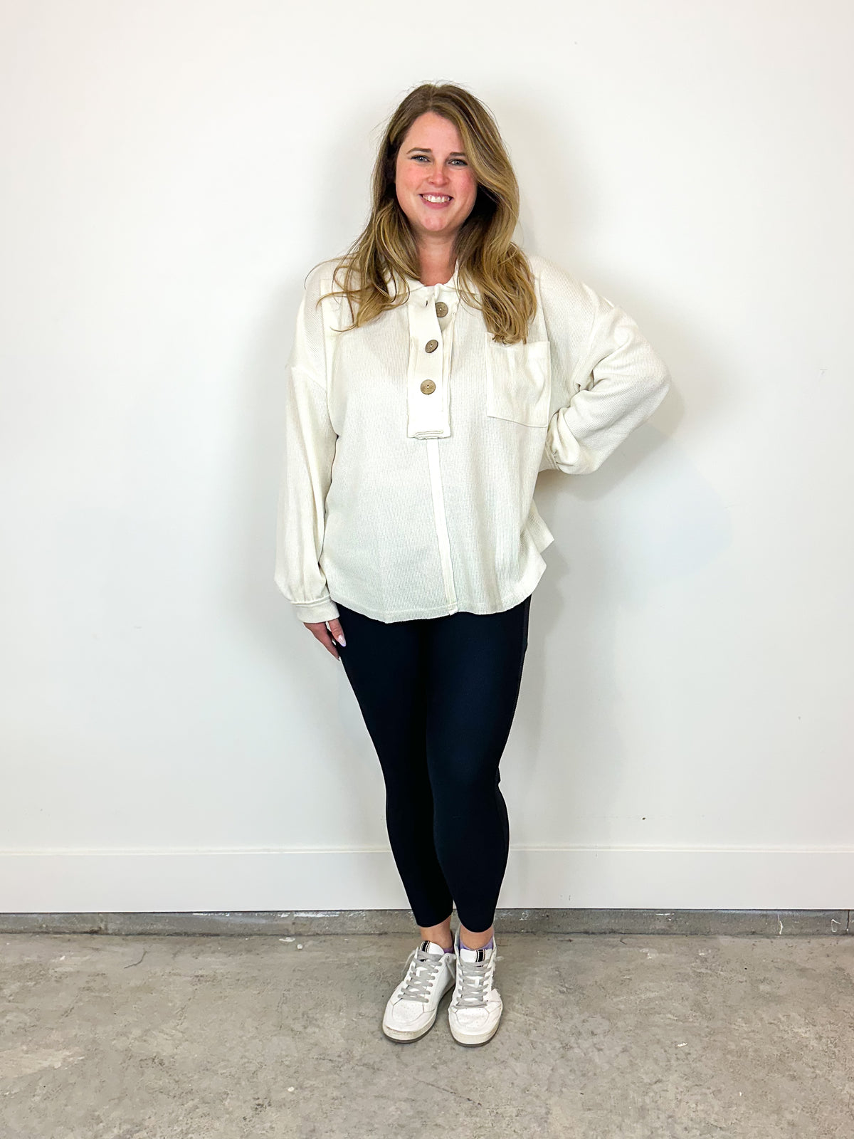 Wearing cream quarter button sweater.